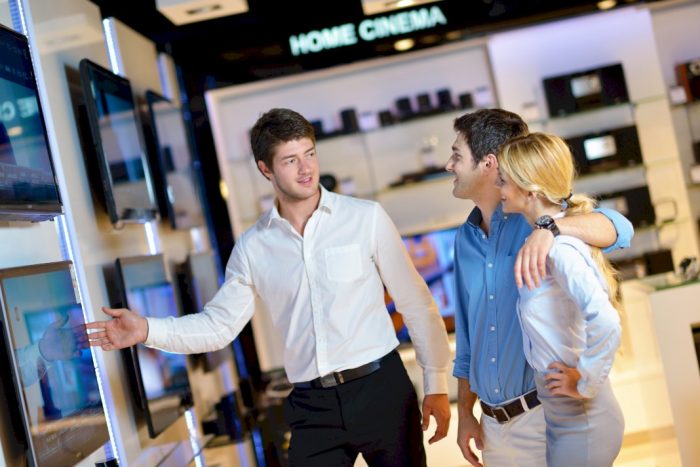man showing couple a home cinema solution in the consumer electronics market