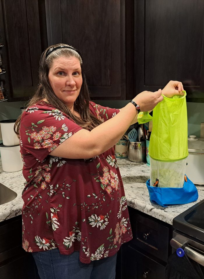 woman holding up the saladzilla salad spinner in a kitchen