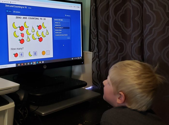 boy looking at online math curriculum zero and counting to 10 fruit and numbers on screen