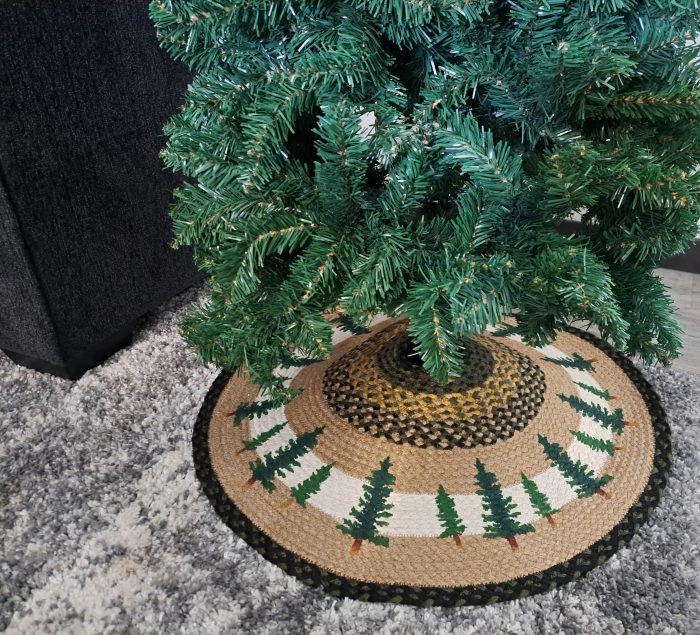 close up view of handpainted Christmas trees on a handcrafted jute tree skirt under an artificial tree