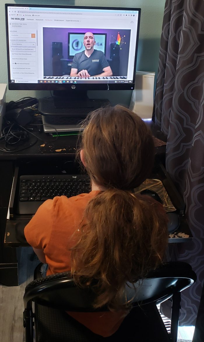 girl watching video to learn homeschool singing lessons