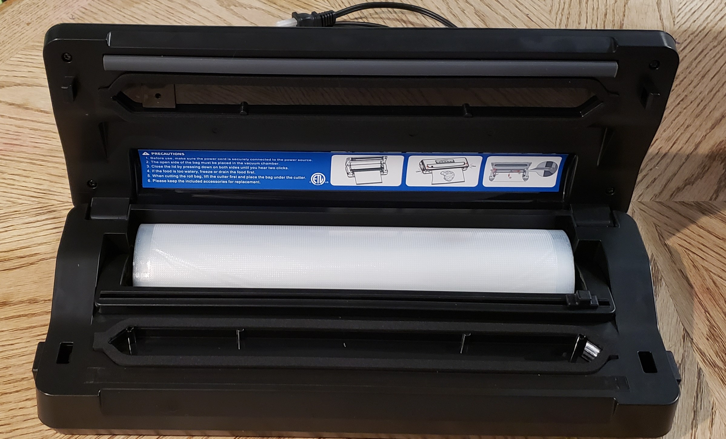 inkbird plus vacuum sealer interior view with bag roll and safety sticker