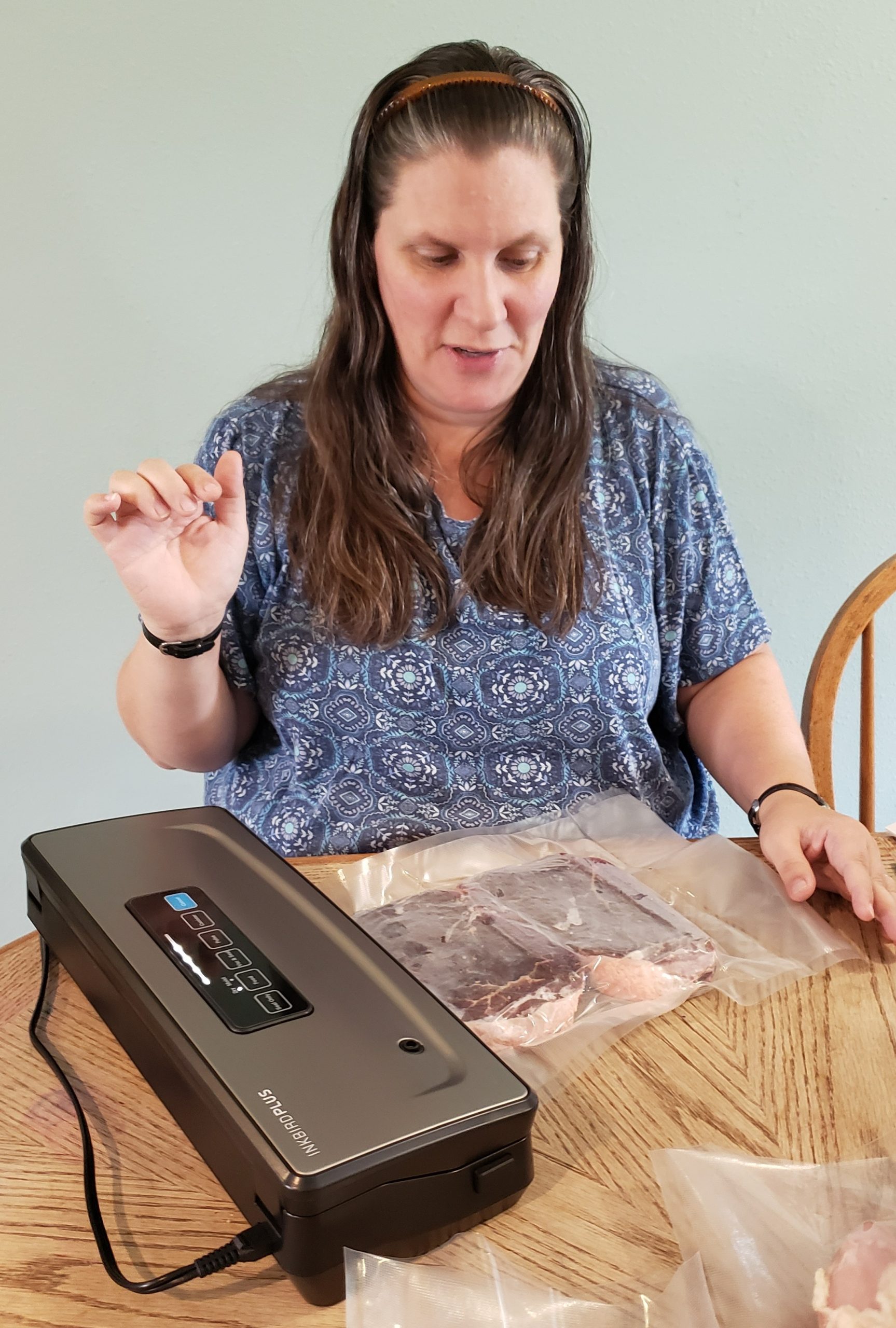 surprised woman reacts to fast suctioning of her steak in the inkbird plus vacuum sealer