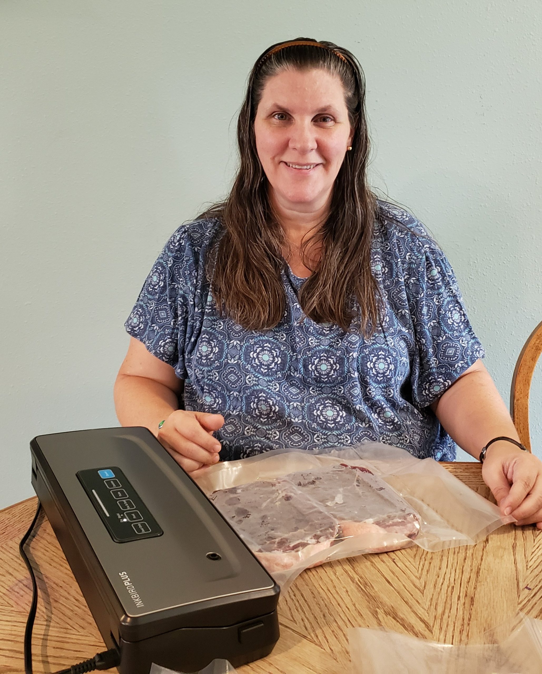 smiling woman after vacuum sealing her steaks with the inkbird plus vacuum sealer