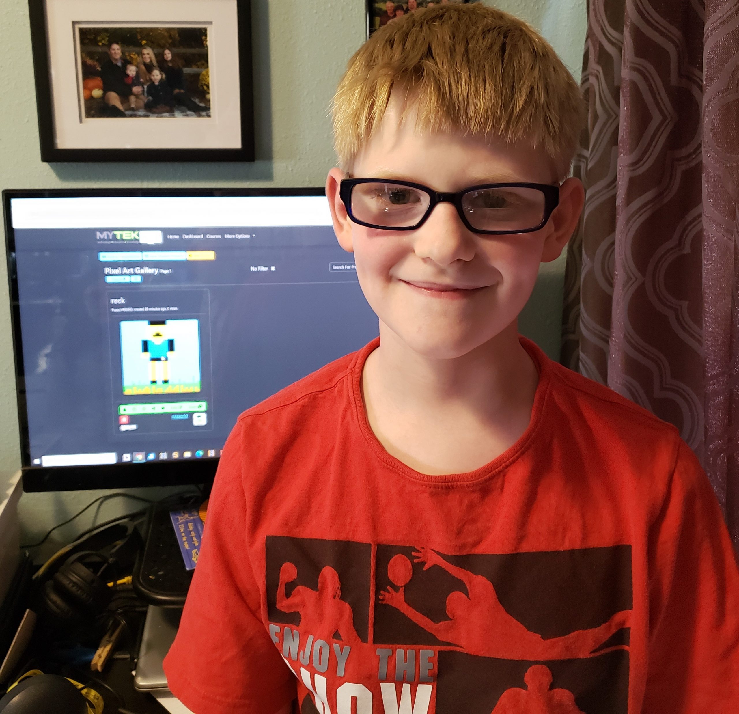 online technology classes smiling boy proudly shows his first image in his pixel art gallery