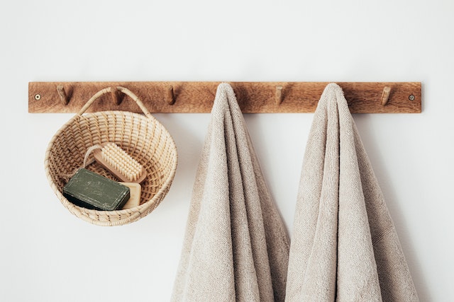 wall mounted peg rack holding towels and basket of bath brushes as a minimalistic look to represent the possibilities of designing an eco home
