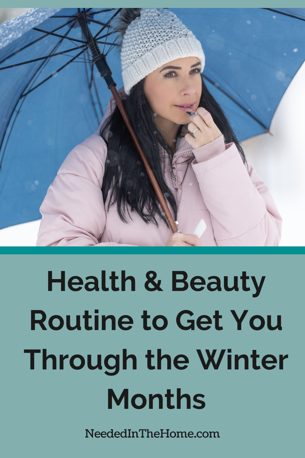 woman holding umbrella putting on lip balm wearing winter coat and hat health and beauty routine to get you through the winter neededinthehome
