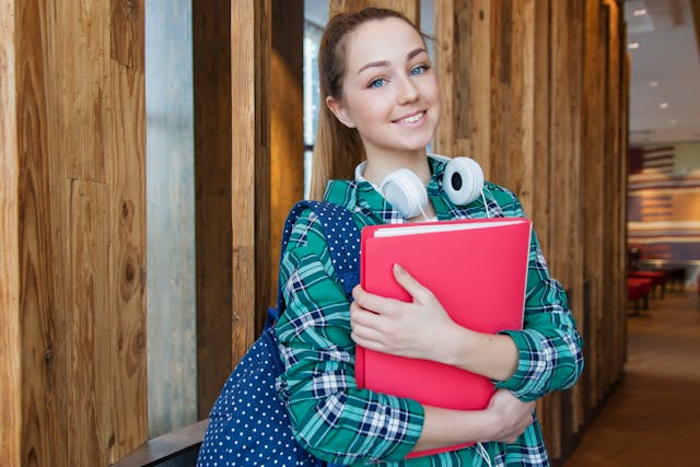 college woman smiling and holding folder