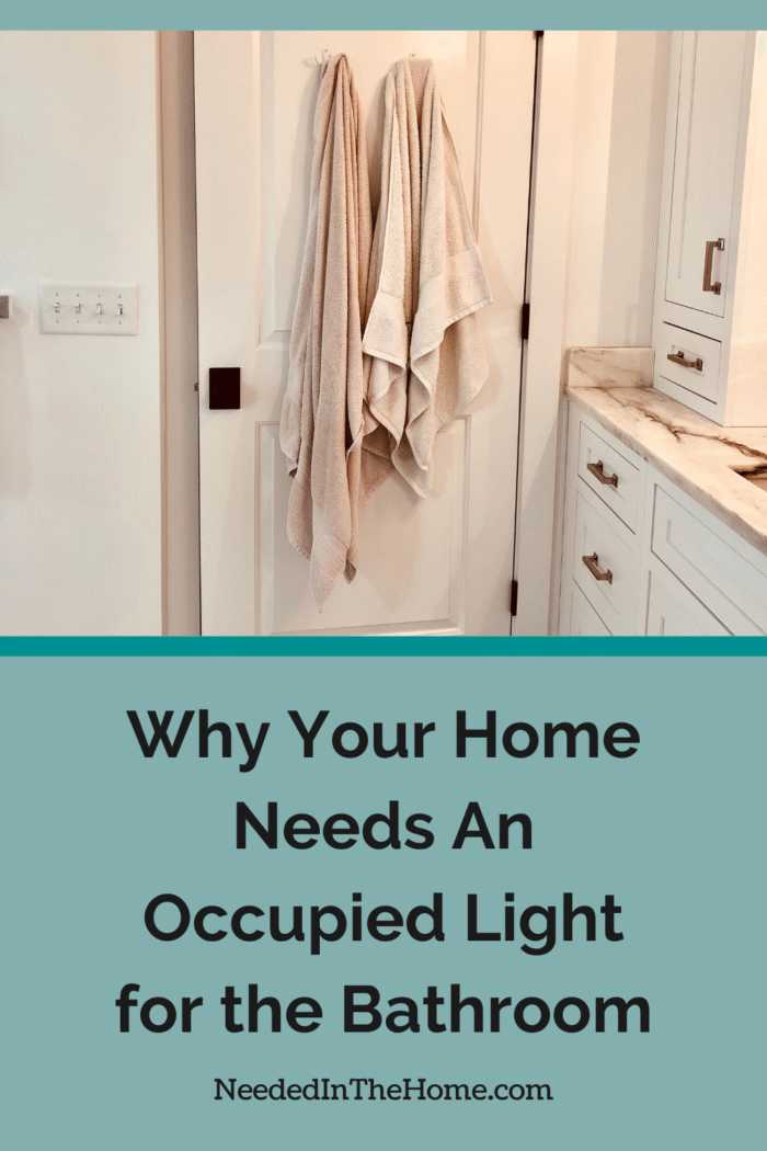 bathroom door starting to open with towels hanging on the back why your home needs an occupied light for the bathroom neededinthehome