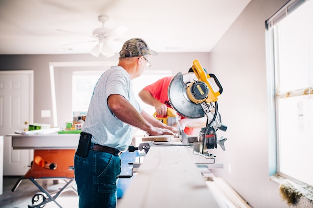 two men working with power tools to get a room ready for fall
