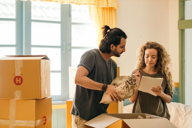 man and woman packing to move with a checklist