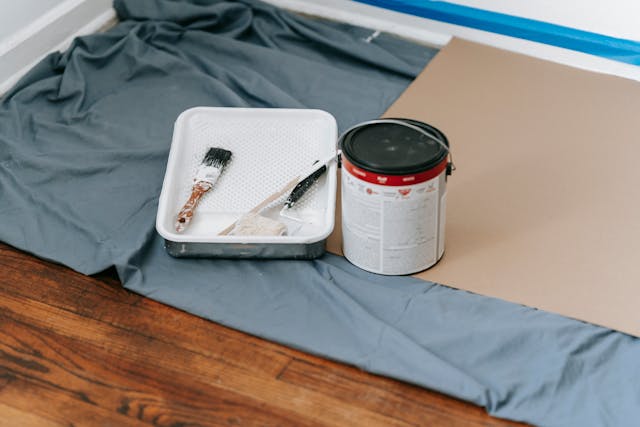 Put a weekend aside to update your home because here are a few updates and improvements that you can get done within a day or two. paint blanket with paint tray brushes and can of paint in corner of a room