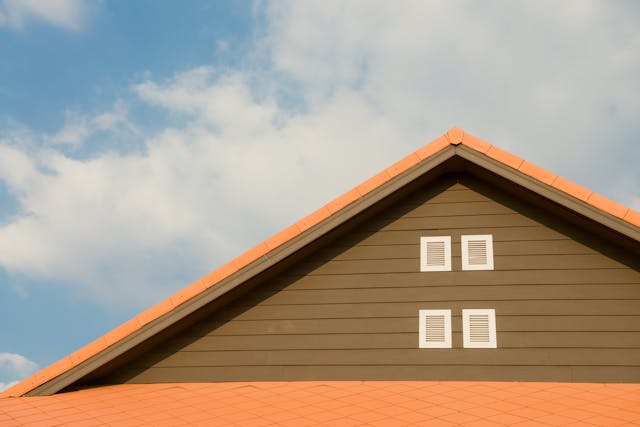 orange roof and brown siding on upper part of a house