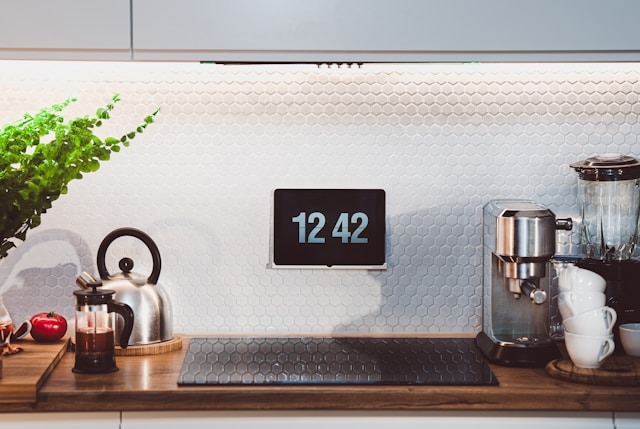 digital clock attached to kitchen wall under cupboard space