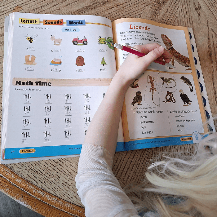 person holding pencil over an evan moor workbook with letters sounds words math science lizards