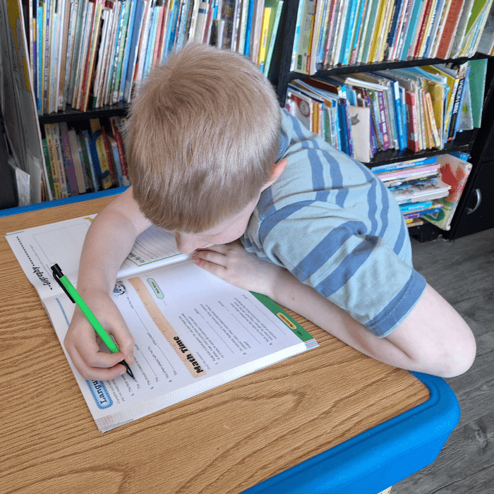 boy writing in his math workbook