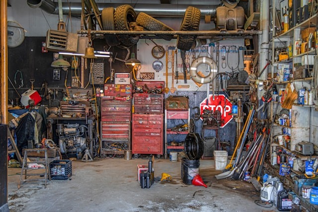 very messy garage with lots of dirty tools tires equipment