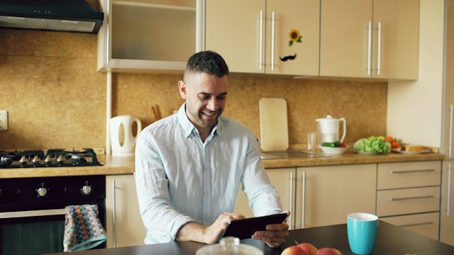 man using ipad in home kitchen to find recipe to make a meal