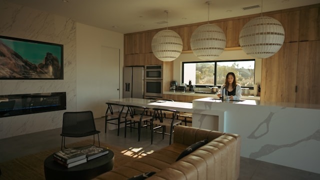 woman filling mug with water in home kitchen in open concept home
