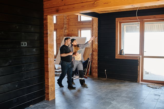 Before you hire a contractor to do work at your home, you should watch for these red flags before you sign anything. people walking through a house during remodeling