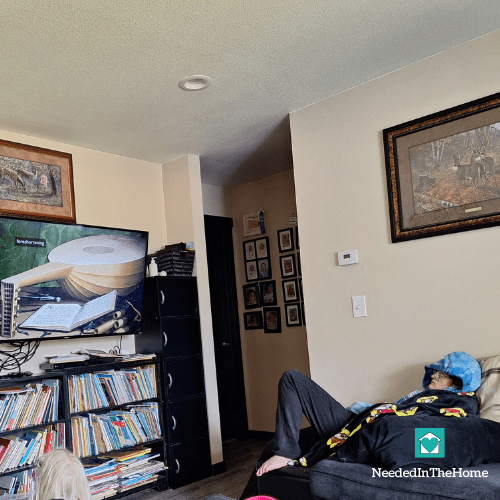 teen girl and young girl in living room watching an art technique video