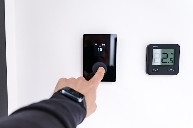 finger pushing button on thermostat