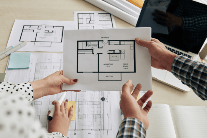 woman and man looking at a blueprints of home designs for their custom built home