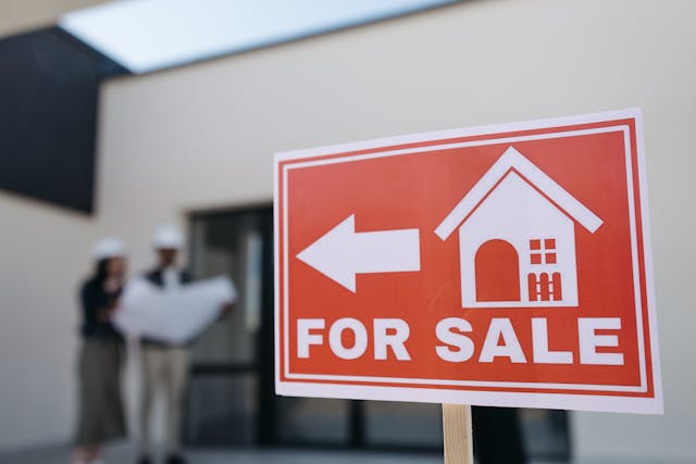 There are many reasons that you may need to sell your home quickly. Here are five things to do to help you along. for sale sign near contractors looking at a blueprint