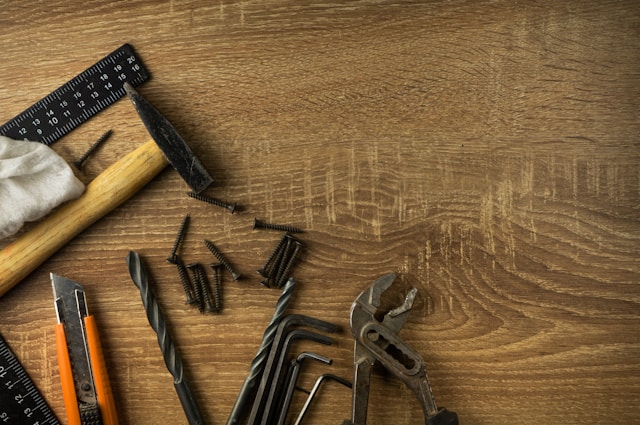 tools and screws laying on a wooden board