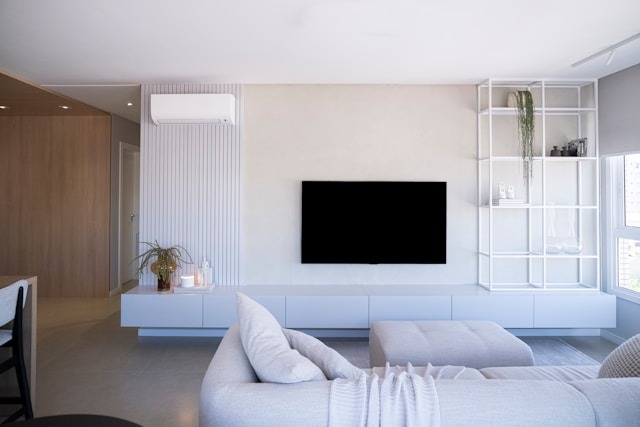 This guide will walk you through the most common types of cooling systems to help you find the perfect match for your home and wallet. living room with an air conditioner unit on the wall