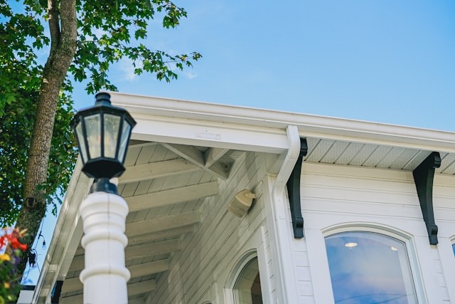 One of the smartest things you can do as a homeowner is to start protecting your home's foundation from water damage as soon as possible. underside view of rain gutters on a house against a blue sky