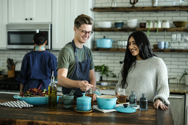 Your space can work with your daily habits instead of against them, start by building your home around the way you live. family in a kitchen getting ready to serve food